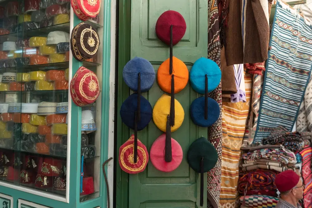 Souk traditionnel tunisien : étals d'épices colorées, tapis berbères et lanternes en cuivre dans la médina