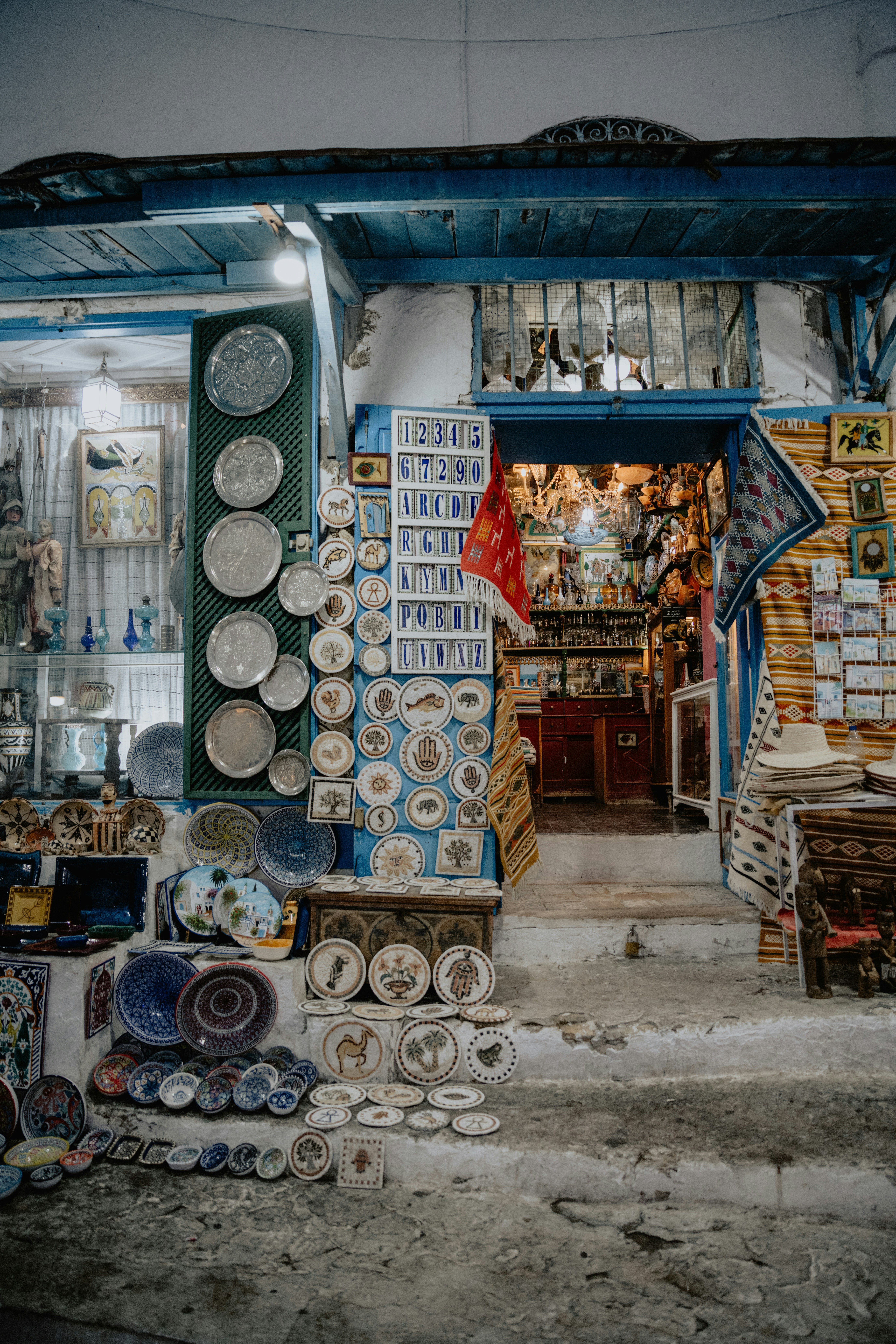 Étal de souvenirs tunisiens : harissa, dattes, céramiques de Nabeul, tapis berbères et huile d'olive